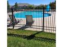 Community pool with lounge chairs and a metal fence at 2855 Rock Creek Cir # 158, Superior, CO 80027