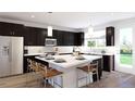 Modern kitchen with dark cabinetry, an island, and stainless steel appliances at 3833 Whispering Sage St, Evergreen, CO 80439