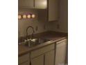 Small kitchen with stainless steel sink and white cabinets at 1845 N Kendall St # 316D, Lakewood, CO 80214
