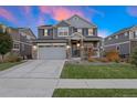 Two-story home with gray siding, attached garage, and landscaped lawn at 23890 E Minnow Dr, Aurora, CO 80016
