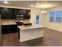 Modern kitchen with dark cabinets, granite island, and stainless steel appliances at 4630 Copeland Cir # 102, Highlands Ranch, CO 80126
