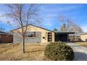 Ranch style home with gray siding, wood accents, and carport at 6035 Everett St, Arvada, CO 80004