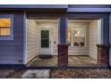 Front porch with brick columns, entry door, and window at 19045 E 57Th Pl, Denver, CO 80249