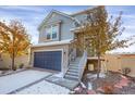 Two-story house with gray siding, a blue garage door, and a gray staircase leading to the entrance at 17938 E 54Th Ave, Denver, CO 80249