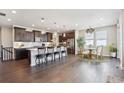 Modern kitchen with dark cabinetry, island, and stainless steel appliances at 24027 E Rockinghorse Pkwy, Aurora, CO 80016