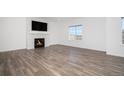 Living room with hardwood floors, fireplace, and large TV at 18235 Caffey Dr, Parker, CO 80134