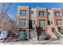 Brick front of a three-story townhome with steps leading to the entrance at 2311 Decatur St, Denver, CO 80211