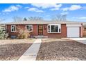 Front view of a ranch style brick home with a well-maintained lawn at 1318 S Ingalls St, Lakewood, CO 80232