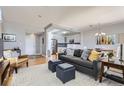 Open living room with gray couch and view into kitchen at 2700 E Cherry Creek South Dr # 313, Denver, CO 80209