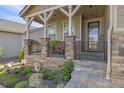 Inviting front porch with brick pillars, metal railing, and hanging planters at 3214 Heron Lakes Pkwy, Berthoud, CO 80513