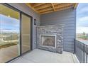Outdoor patio with a stone fireplace and sliding glass door at 1765 Peak Loop, Broomfield, CO 80023