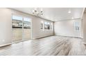 Bright living room with large windows and wood-look floors at 16870 Mckay Dr, Mead, CO 80542