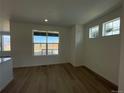 Bright living room with large windows and hardwood floors at 1309 Sunrise Dr, Erie, CO 80516