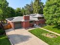 Brick ranch home with solar panels, attached garage, and spacious driveway at 1005 W 7Th Ave Dr, Broomfield, CO 80020