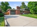 Front exterior view of a brick home with a gray garage door and driveway at 1005 W 7Th Ave Dr, Broomfield, CO 80020