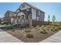 Two-story home with gray siding, stone accents, and landscaped front yard at 4197 N Rome St, Aurora, CO 80019