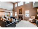 Spacious living room with high ceilings, fireplace, and ample natural light at 12044 Fontberry St, Parker, CO 80134