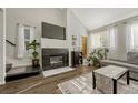 Living room featuring a gas fireplace, hardwood floors, and ample natural light at 970 S Dawson Way # 10, Aurora, CO 80012