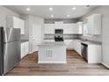 Modern kitchen with white cabinets, granite countertops, and stainless steel appliances at 2204 Alyssa St, Fort Lupton, CO 80621