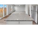 Kitchen island with granite countertop, offering extra prep and seating space at 2204 Alyssa St, Fort Lupton, CO 80621