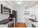 Bright kitchen boasts stainless steel appliances and white shaker cabinets at 3121 S Tamarac Dr # 201K, Denver, CO 80231