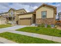 Tan single-story house with a two-car garage and manicured lawn at 9804 Truckee St, Commerce City, CO 80022