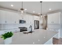 White kitchen cabinets, quartz countertops, and herringbone backsplash at 954 Plum Creek Ct, Brighton, CO 80601