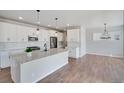 Modern kitchen with white cabinets, quartz countertops, and a large island at 954 Plum Creek Ct, Brighton, CO 80601