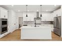 Modern kitchen with white cabinets, quartz countertops, and stainless steel appliances at 42974 Colonial Trl, Elizabeth, CO 80107