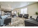 Open concept living and dining area with hardwood floors and gray furniture at 13644 Ulster St, Thornton, CO 80602