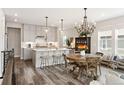 Modern kitchen with island, white cabinets, and chandelier at 17392 W 93Rd Pl, Arvada, CO 80007