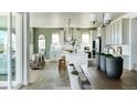 Modern kitchen with white cabinets, an island, and an open floor plan at 16985 Black Rose Pl, Parker, CO 80134