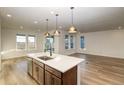 Open-concept kitchen with an island, stainless steel appliances, and light wood cabinets at 23942 E 40Th Ave, Aurora, CO 80019