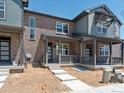 Two-story townhome with brick and siding exterior, covered porch, and landscaping at 22360 E 8Th Ave, Aurora, CO 80018