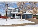 Two-story house with a gray exterior, two-car garage, and snow-covered front yard at 418 Tynan Ct, Erie, CO 80516