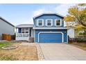 Two-story blue house with attached garage at 6140 E 121St Dr, Brighton, CO 80602