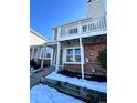 Brick townhouse exterior with balcony, steps, and snowy landscaping at 17136 E Tennessee Dr, Aurora, CO 80017