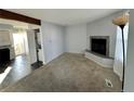 Living room with fireplace, carpet, and view into kitchen at 17136 E Tennessee Dr, Aurora, CO 80017