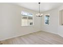 Simple dining room with hardwood floors, chandelier, and large windows at 7357 S Waterloo Way, Aurora, CO 80016