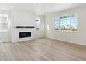 Spacious living room with hardwood floors, fireplace, and large windows at 7357 S Waterloo Way, Aurora, CO 80016