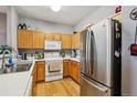 Kitchen boasts ample counter space, wood cabinetry, and modern stainless steel appliances at 126 Foxglove Dr, Brighton, CO 80601