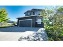 Two-story house with gray siding, stone accents, and a two-car garage at 26994 E Indore Ave, Aurora, CO 80016