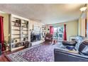 Bright living room with hardwood floors and fireplace at 9676 Rensselaer Dr, Arvada, CO 80004