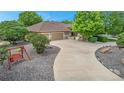 Inviting front yard with a paved driveway, mature trees, and a charming porch swing at 6631 E 167Th Ave, Brighton, CO 80602