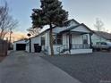 White house with a gravel driveway and a detached garage at 3114 W Gill Pl, Denver, CO 80219