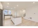 Open concept kitchen with white cabinets, island, and stainless steel appliances at 14554 W 91St Dr # A, Arvada, CO 80005