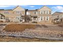 Tan two-story townhome with stone accents and a small front yard at 12740 Jasmine St # E, Thornton, CO 80602