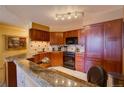 Well-equipped kitchen with granite countertops and dark wood cabinetry at 1625 Larimer St # 904, Denver, CO 80202