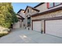 Two-story house with stone exterior, three car garage, and landscaping at 5033 Silver Feather Way, Broomfield, CO 80023