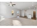Open living room with carpet, sliding glass door, and ceiling fan at 2971 Pershing St, Strasburg, CO 80136